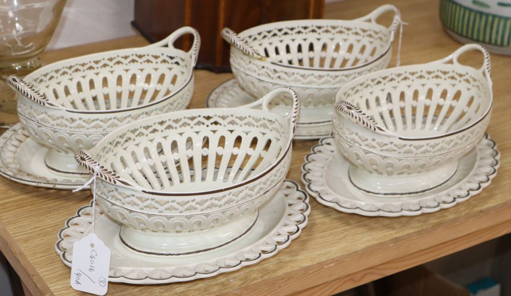 A pair of late 18th century creamware chestnut baskets and stands, a similar pair of baskets with associated Herculaneum stands